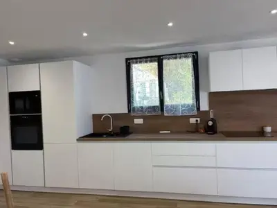 a kitchen with white cabinets and a window at Rez de villa Proche d'Ajaccio in Sarrola-Carcopino