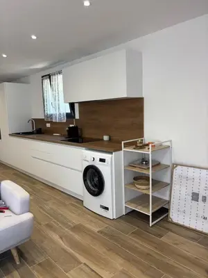 a kitchen with a washing machine in a kitchen at Rez de villa Proche d'Ajaccio in Sarrola-Carcopino