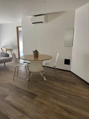 a dining room with a table and chairs and a couch at Rez de villa Proche d'Ajaccio in Sarrola-Carcopino