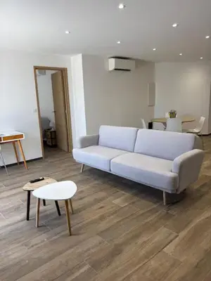 a living room with a couch and a table at Rez de villa Proche d'Ajaccio in Sarrola-Carcopino