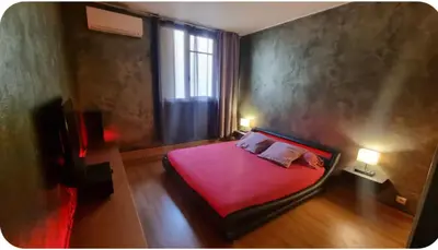 a bedroom with a pink bed and a window at Spacieux T2 route des sanguinaires in Ajaccio