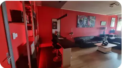 a living room with red walls and a couch at Spacieux T2 route des sanguinaires in Ajaccio