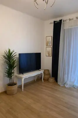 a living room with a flat screen tv on a table at Lumineux T3 avec double terrasse au calme - parking sécurisé in Ajaccio