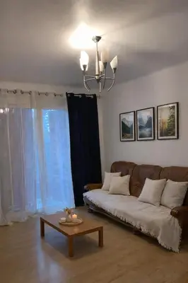 a living room with a couch and a table at Lumineux T3 avec double terrasse au calme - parking sécurisé in Ajaccio