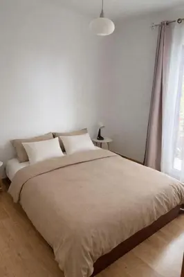 a large white bed in a room with white cabinets at Lumineux T3 avec double terrasse au calme - parking sécurisé in Ajaccio