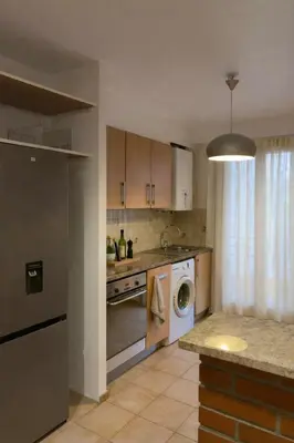 a kitchen with a washing machine and a washer at Lumineux T3 avec double terrasse au calme - parking sécurisé in Ajaccio