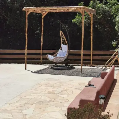 a chair sitting under a gazebo in a patio at Villa 140 m2 avec piscine, parc privatif 5000m2 à Bonifacio-Porto Vecchio in Bonifacio