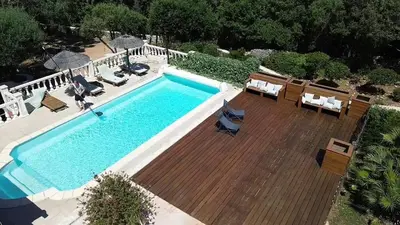 an overhead view of a pool with chairs and a wooden deck at Villa 140 m2 avec piscine, parc privatif 5000m2 à Bonifacio-Porto Vecchio in Bonifacio