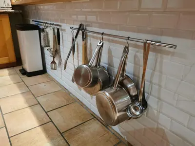 a bunch of pots and pans hanging on a wall at Villa 140 m2 avec piscine, parc privatif 5000m2 à Bonifacio-Porto Vecchio in Bonifacio