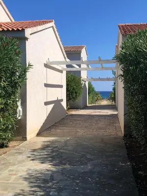 a white pergola over a walkway between two buildings at Villa A Nuciola - Prunete in Cervione