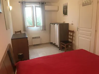 a room with a bed and a refrigerator and a window at Villa A Nuciola - Prunete in Cervione
