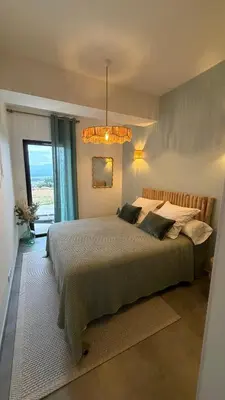 a bedroom with a large bed and a large window at Baia Serena in Ajaccio