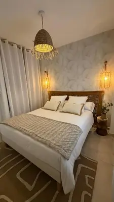 a bedroom with a large bed and a chandelier at Baia Serena in Ajaccio