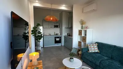 a living room with a green couch and a kitchen at Baia Serena in Ajaccio