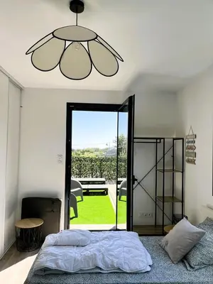 a bedroom with a bed and a chandelier at L'Immortelle in Zonza