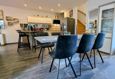 a kitchen and dining room with a table and chairs at L'Immortelle in Zonza