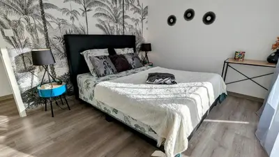 a bedroom with a bed with a black headboard at L'Immortelle in Zonza