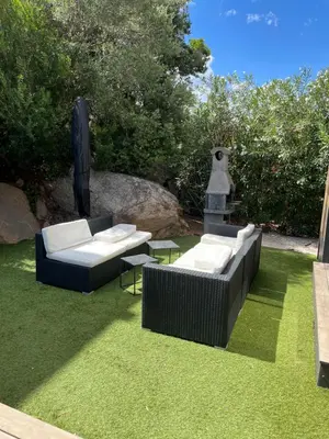 two couches and chairs on the grass in a yard at L'Immortelle in Zonza