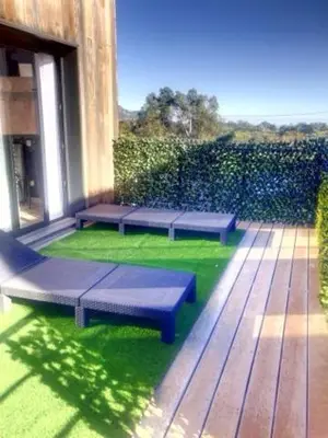 a patio with benches on the grass on a building at L'Immortelle in Zonza