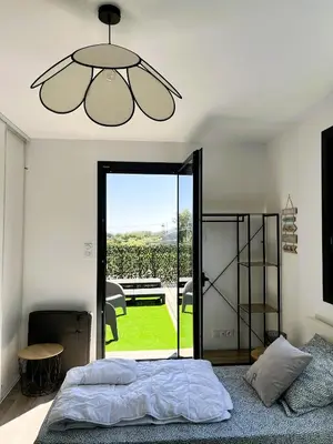 a bedroom with a bed and a large glass door at L'Immortelle in Zonza