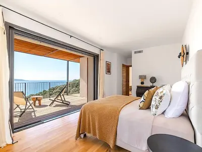 a bedroom with a bed and a view of the ocean at Villa Paolina in Olmeto