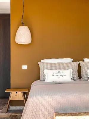 a bedroom with a bed with a yellow wall at Villa Paolina in Olmeto