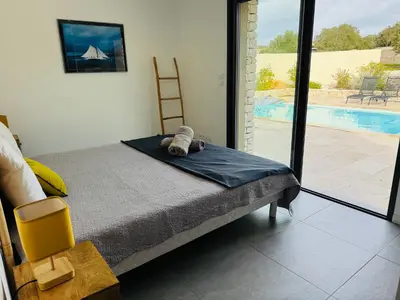 a bedroom with a bed and a view of a pool at Casa Caseddu, Heated pool, 4 people, Bonifacio in Bonifacio
