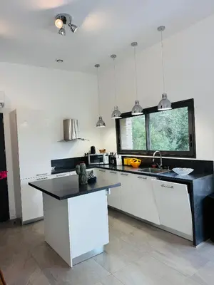 a kitchen with white cabinets and a black counter top at Casa Caseddu, Heated pool, 4 people, Bonifacio in Bonifacio
