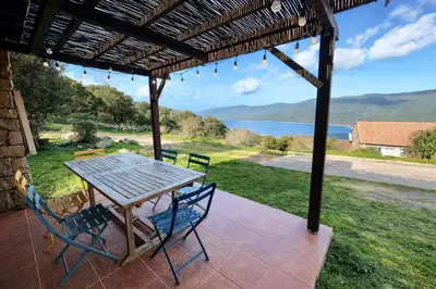 a table and chairs on a patio with a view of the water at Villa - 8 personnes - Soléa 3 - vue mer in Serra-di-Ferro