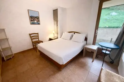 a bedroom with a bed and a table and a window at Villa - 8 personnes - Soléa 3 - vue mer in Serra-di-Ferro