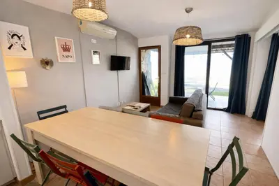 a living room with a table and a couch at Villa - 8 personnes - Soléa 3 - vue mer in Serra-di-Ferro