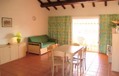 a kitchen and living room with a table and a couch at Residence Sognu di Mare in Linguizzetta