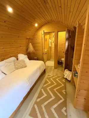 a bedroom with a bed in a wooden cabin at Roulotte Atypique - Vue Mer - Écrin de Nature in Cauro