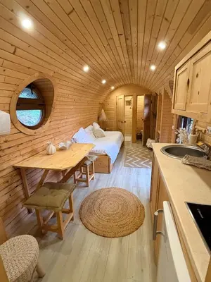 a room with a bed and a table in a cabin at Roulotte Atypique - Vue Mer - Écrin de Nature in Cauro