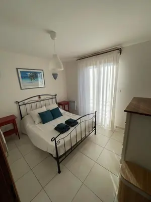 a bedroom with a bed in a room with a window at Casa di Piero e Anna in Porto-Vecchio