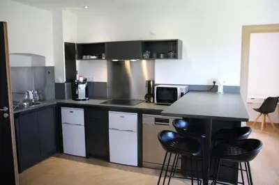 a kitchen with black cabinets and a black counter top at Casa di a Volpe in Corte
