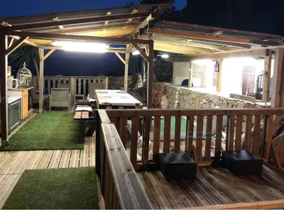 a wooden deck with a table and bench on it at Chalet stella in Olmeto