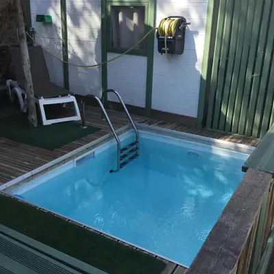 a swimming pool with a hose connected to a house at Chalet stella in Olmeto