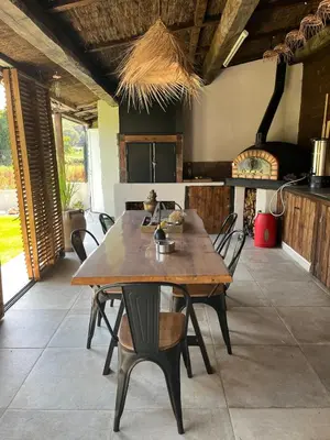 a dining room with a wooden table and chairs at Maison de charme entre mer et nature 4pers in Cervione