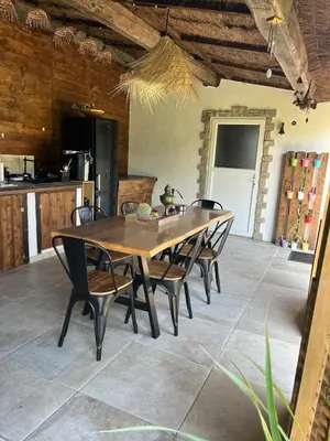 a dining room with a wooden table and chairs at Maison de charme entre mer et nature 4pers in Cervione