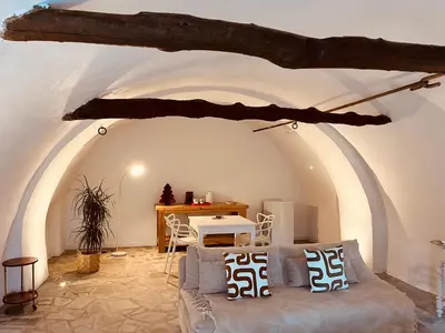 a living room with a couch and a table at Suite avec jardin et piscine in Murato