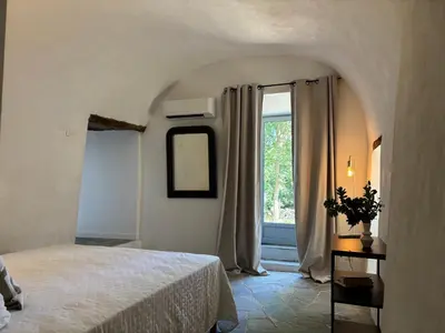 a bedroom with a large bed and a window at Suite avec jardin et piscine in Murato