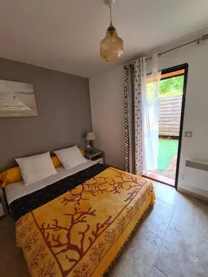 a bedroom with a bed and a large window at U ghjosu rossu, Maison indépendante, bien située in Appietto