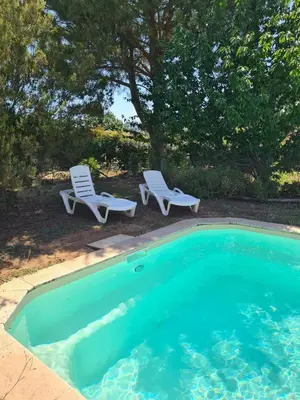 two lawn chairs and two chairs next to a swimming pool at U ghjosu rossu, Maison indépendante, bien située in Appietto