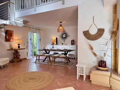 a living room with a table and chairs in it at Villa avec piscine - Cala Rossa - Accès plage in Lecci