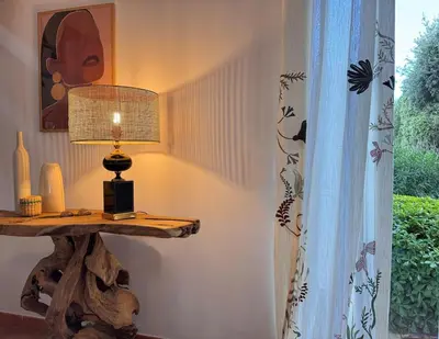 a table with a lamp on it next to a window at Villa avec piscine - Cala Rossa - Accès plage in Lecci