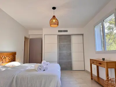 a bedroom with a bed with towels on it at Villa avec piscine - Cala Rossa - Accès plage in Lecci