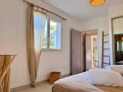 a bedroom with a bed and a window at Villa avec piscine - Cala Rossa - Accès plage in Lecci