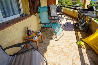 a group of chairs and a table on a balcony at A nostra casetta corsa, Carina, en bord de mer in Ghisonaccia