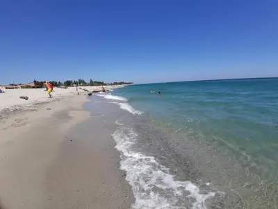 a beach with people swimming in the ocean at A nostra casetta corsa, Carina, en bord de mer in Ghisonaccia